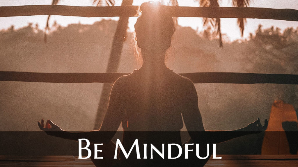 Woman working from home practicing mindfulness when they work-from-home. Image captioned "Be Mindful."